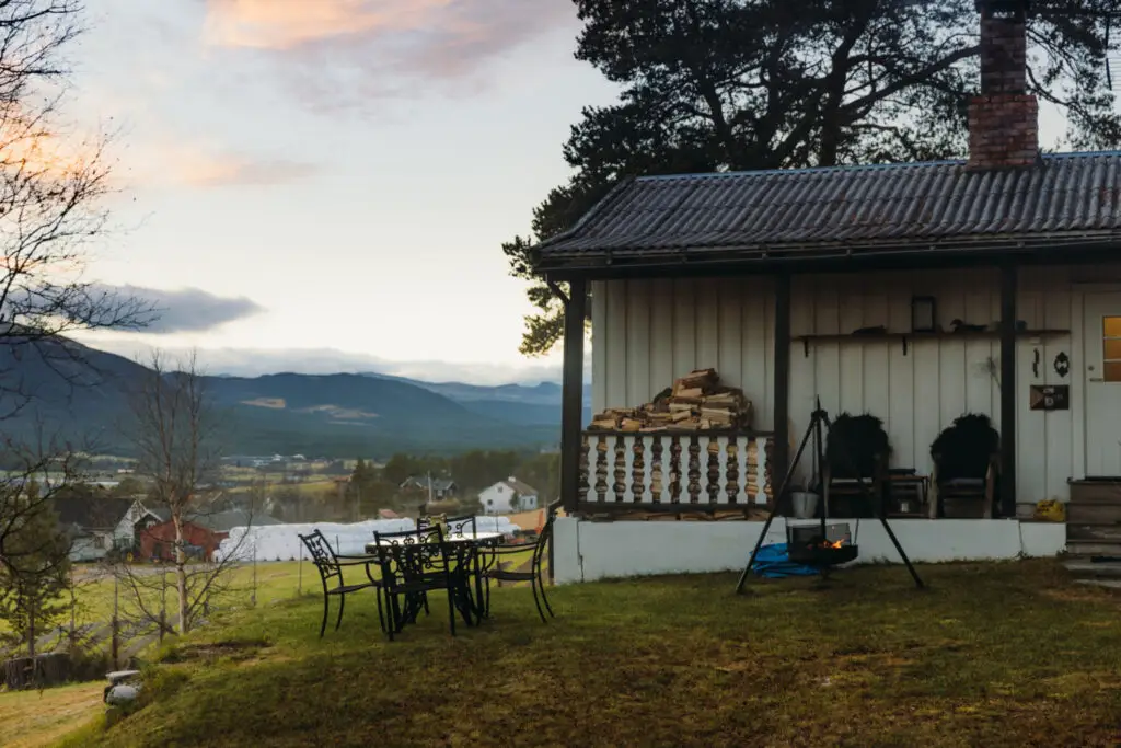 Mountain lodge style home at dusk with a valley and ridgeline behind it